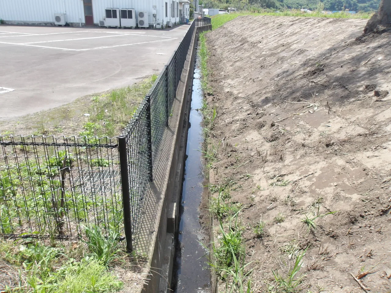 施設脇の排水路と法面